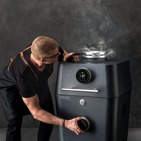 sfeerbeeld van de Everdure 4K met een staande Heston Blumenthal die aan een knop zit in het graphite te koop bij My Cool Kitchen